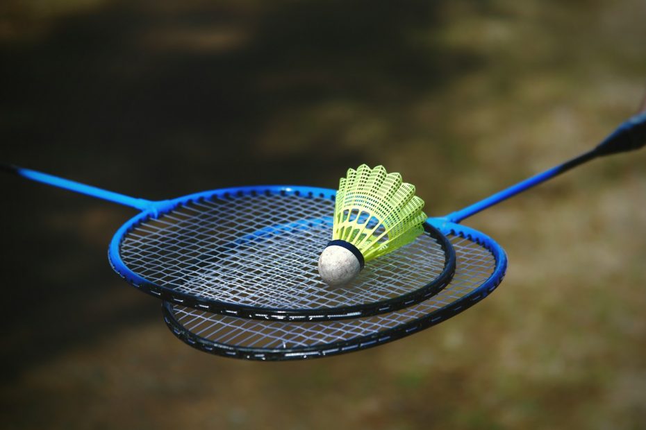 a badminton racket and a tennis ball on a racket
